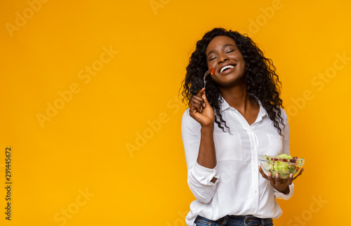 Tableau sur Toile Happy african american woman enjoying vegetable salad