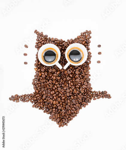 Owl made of roasted coffee beans and two cups. A symbol for night people. Love Coffee. Coffee break. Coffee Time.