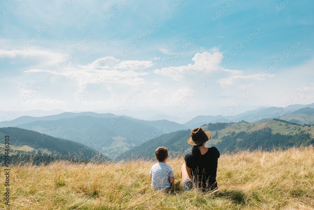 Fototapeta premium Young mom with baby boy travelling. Mother on hiking adventure with child, family trip in mountains. National Park. Hike with children. Active summer holidays.