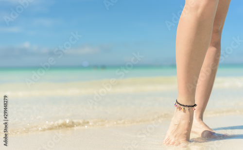 Beach travel concept. Sexy Legs on Tropical Sand Beach. Walking Female Feet. Closeup