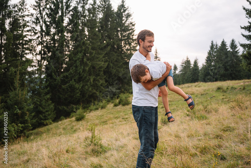 Father and child hiking in scenic mountains. Dad and son enjoying the view from the mountain top in Carpathian mountains