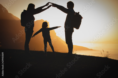 happy family- mom, dad and little girl- travel in mountains at sunset