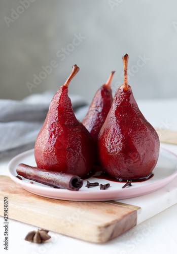 Red wine poached pears in white plate, delicious french dessert, copy space