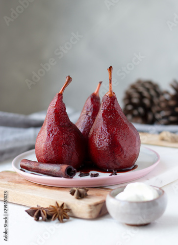 Red wine poached pears in white plate, delicious winter french dessert, copy space
