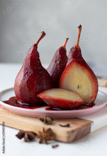 Red wine poached pears in white plate, delicious french dessert