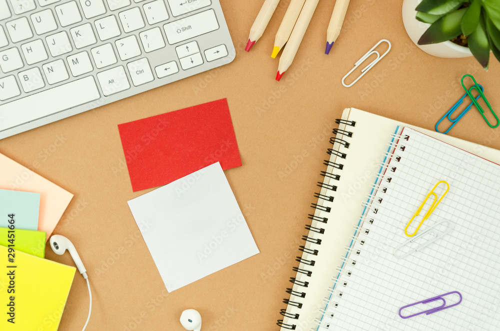 Flat lay student desktop with stationary, computer keyboard, earphones, notepads and sticky notes with copy sapce. Top view mockup Flat lay student desktop with stationary, computer keyboard, earphones, notepads and sticky notes with copy sapce. Top view mockup