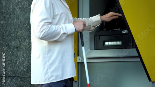 Schilderij op canvas Blind man withdrawing money from atm, searching tactile indicator to insert card