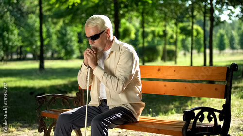 Cuadro en lienzo Depressed blind man sitting alone in park, socially disadvantaged population