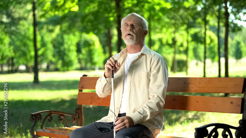 Visually impaired man trying to see park, vision loss from ageing, cataract photo