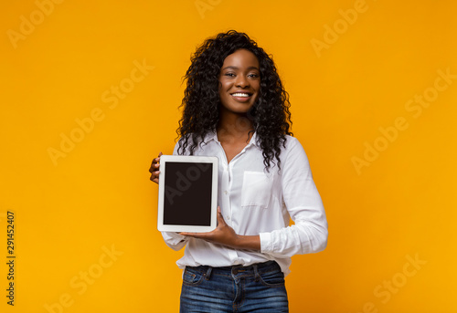 Cheerful black woman demonstrating blank digital tablet screen