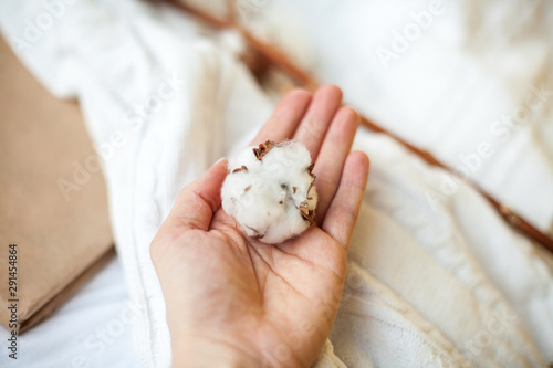 Close-up. Female hands hold cotton on the background of the bed. Cozy. Autumn. Winter.