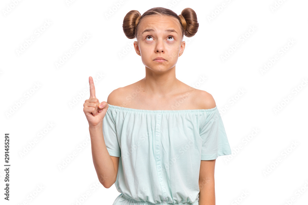 Portrait of teen girl pointing finger up at copyspace, isolated on white background. Beautiful caucasian young teenager attracted by attention pointing finger at something. Surprised or amazed child. Portrait of teen girl pointing finger up at copyspace, isolated on white background. Beautiful caucasian young teenager attracted by attention pointing finger at something. Surprised or amazed child.