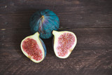 Fig fruits. Still life of figs on a dark wooden table. Cut fruit into pieces. Slices of juicy fruit.