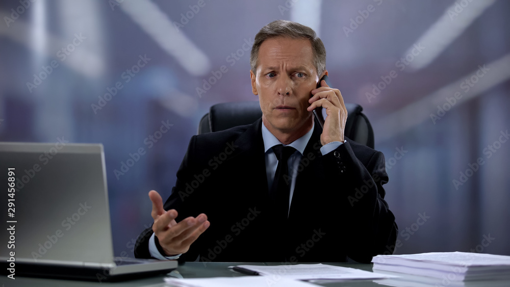 Stressed company male boss talking phone with employee at workplace, deadline Stressed company male boss talking phone with employee at workplace, deadline