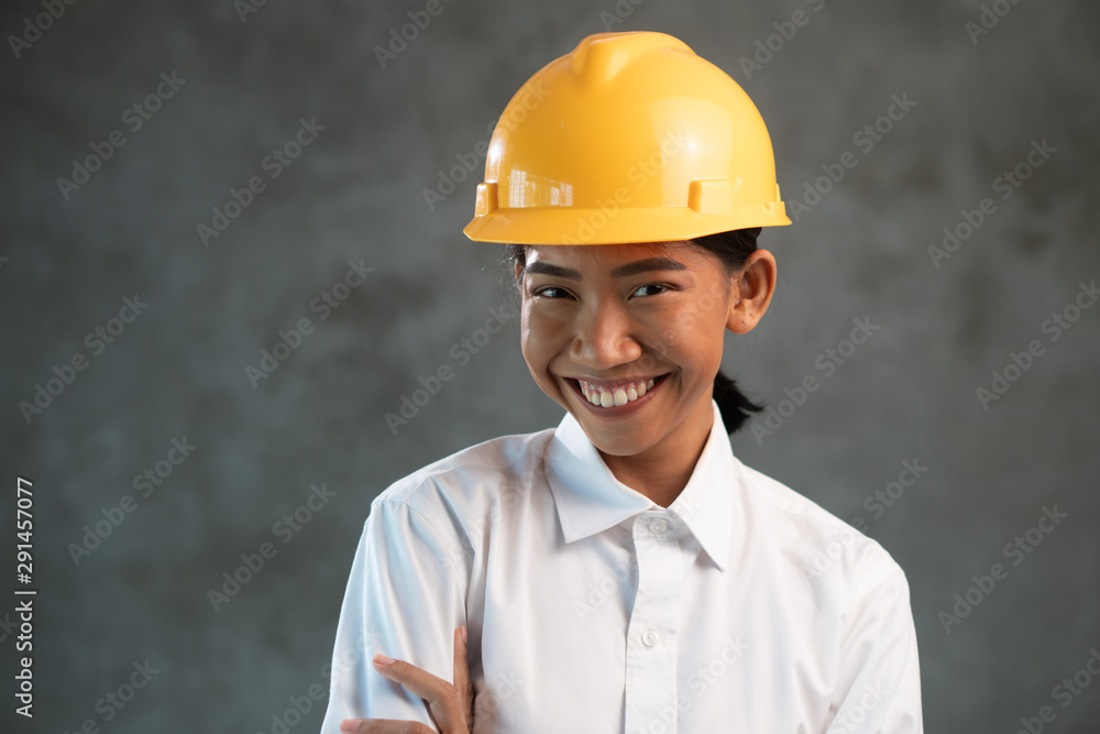 Portrait of smiling attractive Asian woman engineer over concrete wall background Portrait of smiling attractive Asian woman engineer over concrete wall background