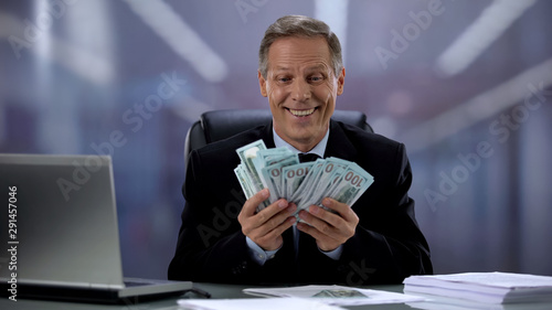 Fotografie, Obraz Greedy businessman holding bunch of dollars, rejoicing easy income, high salary