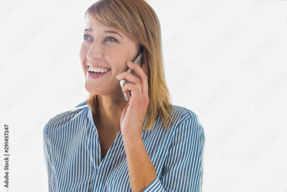 Smiling businesswoman talking on smartphone in office