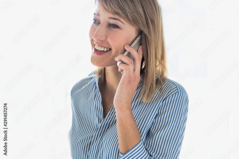Smiling businesswoman talking on smartphone in office Smiling businesswoman talking on smartphone in office