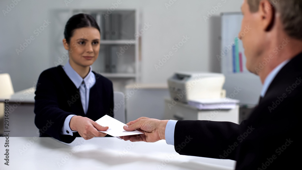 Businessman giving woman envelope, bribery concept, illegal business deal Businessman giving woman envelope, bribery concept, illegal business deal