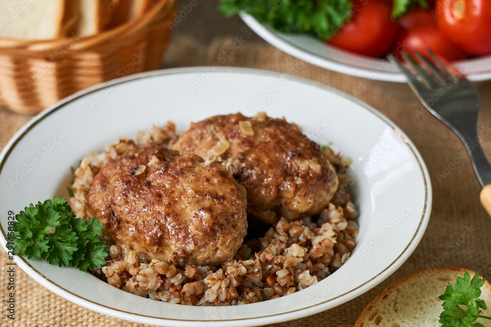 Fried meat cutlets with buckwheat in a white bowl Fried meat cutlets with buckwheat in a white bowl