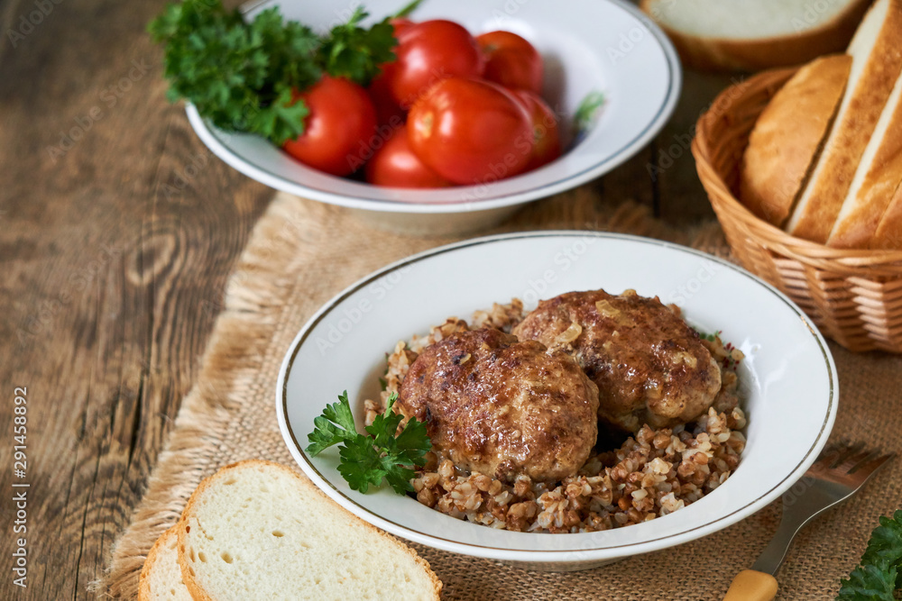 Fried meat cutlets with buckwheat in a white bowl Fried meat cutlets with buckwheat in a white bowl