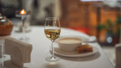 a glass of white wine on the table on the background of food
