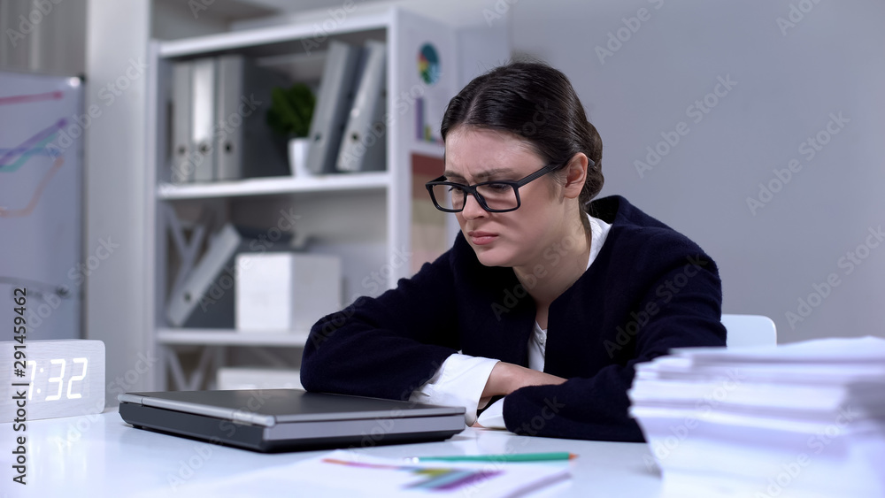 Frustrated woman in business suit sitting with closed laptop, overwork problem Frustrated woman in business suit sitting with closed laptop, overwork problem