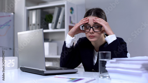 Exhausted businesswoman suffering migraine as result of workload, stressful job