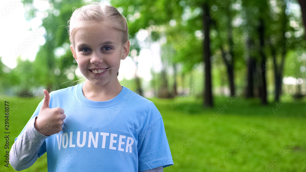 Joyful little volunteer showing thumbs up, eco project recommendation, help Joyful little volunteer showing thumbs up, eco project recommendation, help