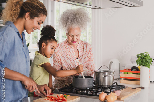 Three generations of family cooking a meal together photo