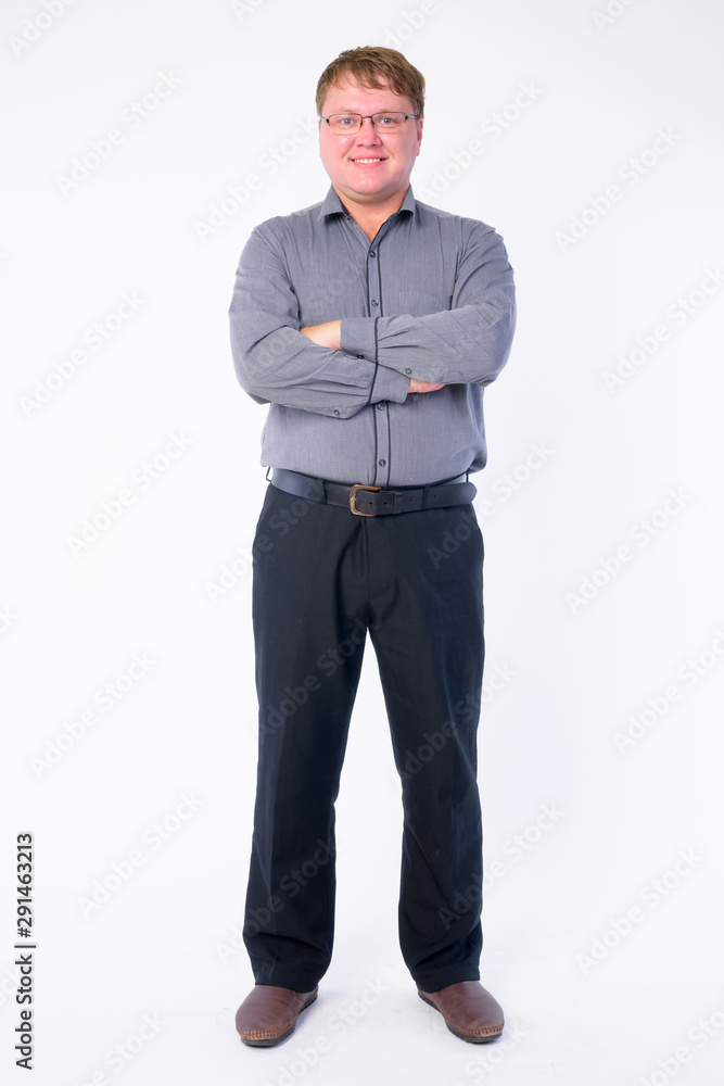 Full body shot of happy overweight businessman smiling with arms crossed Full body shot of happy overweight businessman smiling with arms crossed