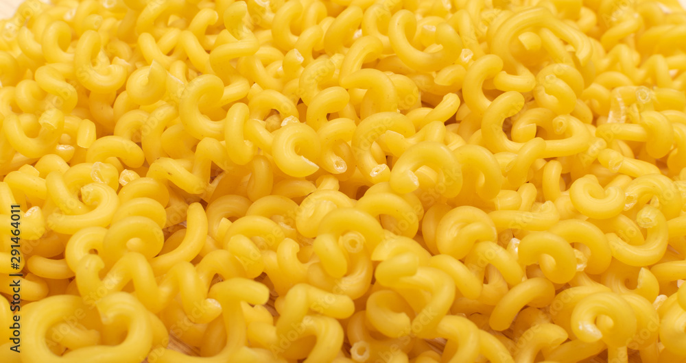 Macro shot of raw yellow cavatappi pasta texture background Macro shot of raw yellow cavatappi pasta texture background