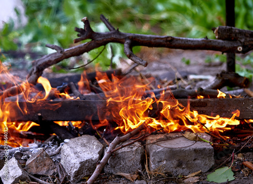 bonfire burns in a meadow, rural landscape