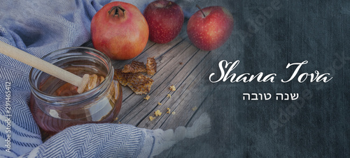 Jewish National Holiday. Rosh Hashana with honey, apple and pomegranate on wooden table. Text: Shana Tova photo