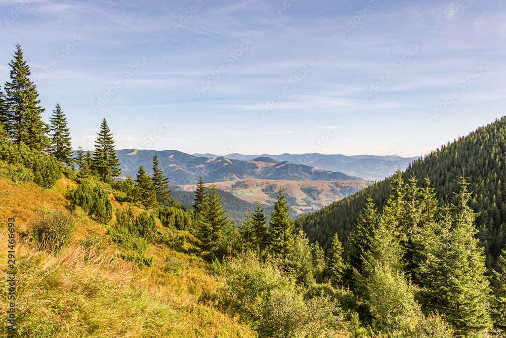 Obraz premium Scenery of the Carpathians centered between two hills shot from the top of the mountain on a bright September day