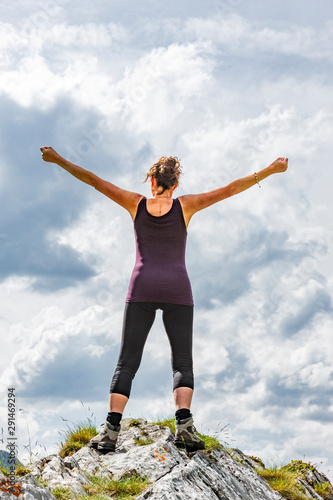 Weibliche Silhouette in Siegerpose auf einem Berggipfel