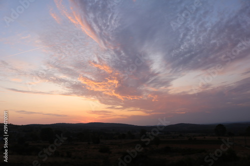 CIELO PARCIALMENTE NUBLADO AL ATARDECER CON UNA MONTAÑA DE FONDO