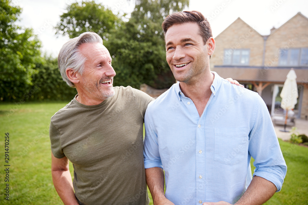 Senior Father And Adult Son Walking And Talking In Garden Together Senior Father And Adult Son Walking And Talking In Garden Together