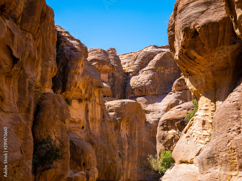 High sandstone mountains as walls of a canyon in the valley of Petra, Jordan