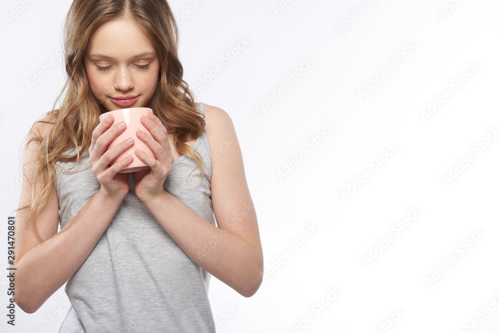 Beautiful teen girl with closed eyes holding pink cup of coffee Beautiful teen girl with closed eyes holding pink cup of coffee