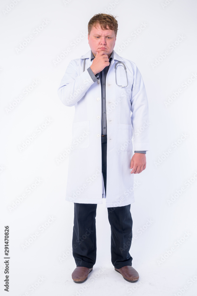 Full body shot of overweight man doctor thinking and looking down Full body shot of overweight man doctor thinking and looking down