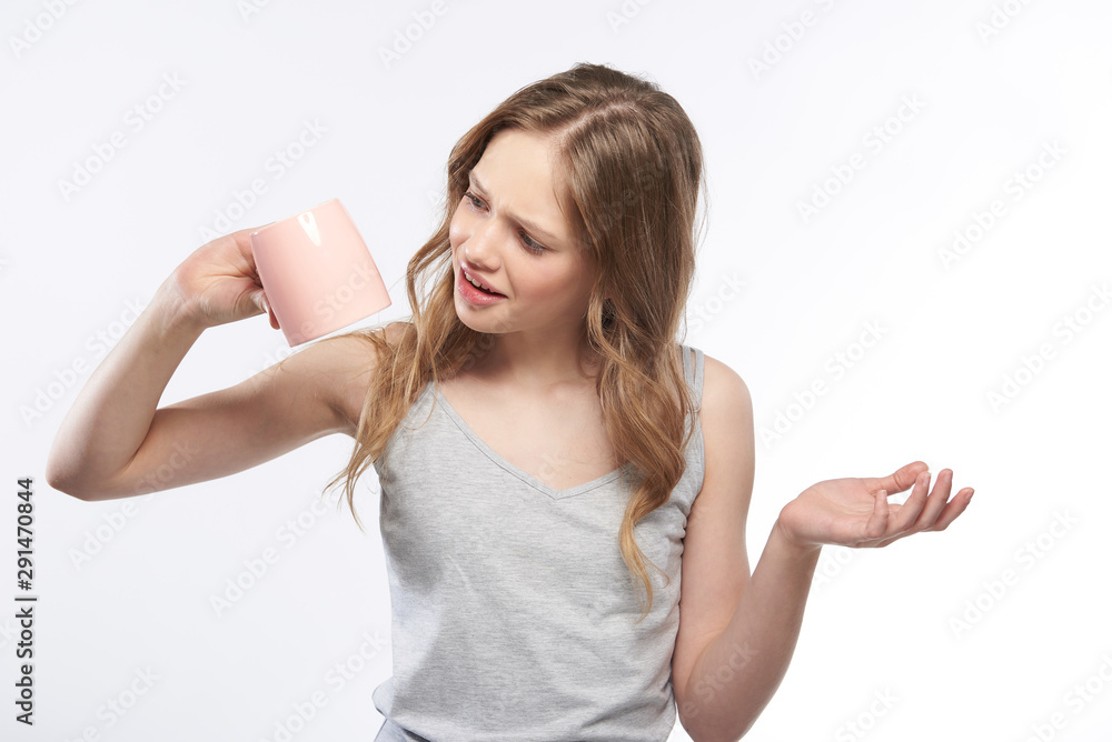 Beautiful teen girl turning empty coffee cup upside down Beautiful teen girl turning empty coffee cup upside down