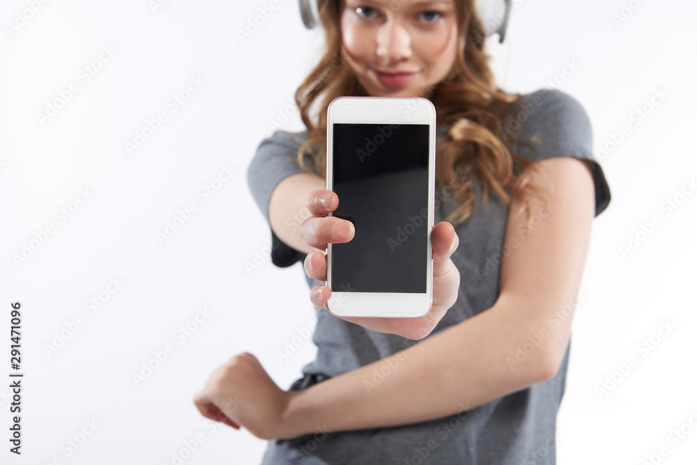 Cute teen girl in t-shirt demonstrating modern cellphone