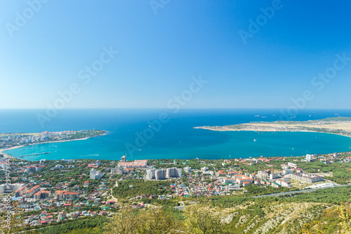 Aerial view of Gelendzhik sea bay. Buildings, beaches, ships in blue water of Black sea bay and horizon in frame.