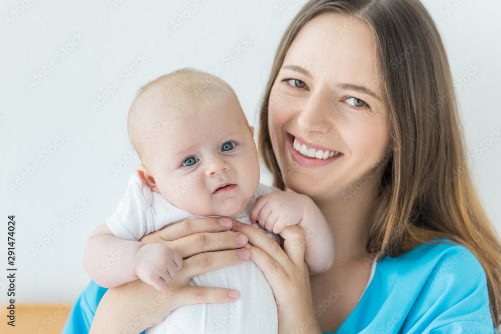 attractive and smiling mother holding her child in hospital attractive and smiling mother holding her child in hospital