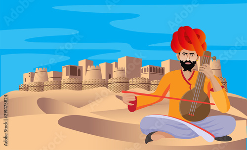 cultural rajasthani folk musician playing music instrument in desert , fort in background photo