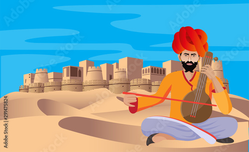 cultural rajasthani folk musician playing music instrument in desert , fort in background