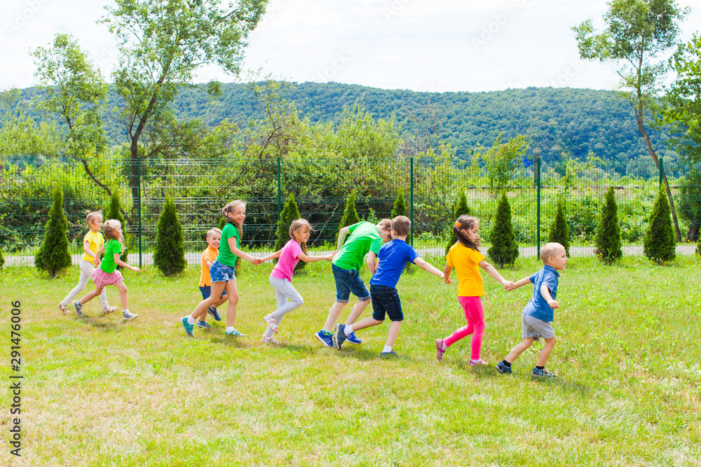 Fototapeta premium Kids running holding hands at the lawn