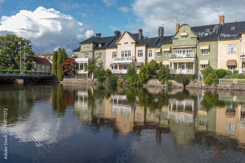 Multicolored houses are reflected in the river. The city of Orebro in Sweden. Travel photo. Background photo.