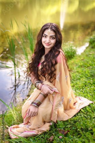 Woman in saree sitting near the river and smiling